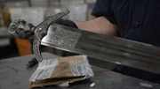 CBP-Beamter Cisneros inspiziert ein Schwert, das in einem verschickten Paket in der Poststelle des JFK International Airport in New York gefunden wurde.