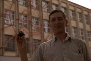 Chelyabinsk, Russia: Production crew V. Molodzievsky holding a piece of the meteorite in front of an old soviet factory.