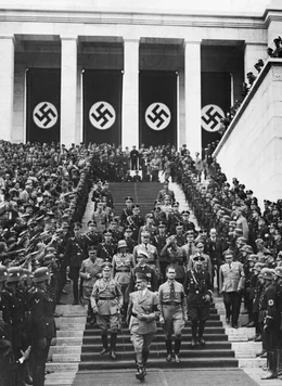 Adolf Hitler l&auml;uft mit seiner Gefolgschaft eine Treppe hinunter.  Die Verwendung des sendungsbezogenen Materials ist nur mit dem Hinweis und Verlinkung auf RTL+ gestattet.  +++ Die Verwendung des sendungsbezogenen Materials ist nur mit dem Hinweis und Verlinkung auf RTL+ gestattet. +++