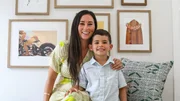Tristyn sits with her son, Bubba, on a bench in the newly renovated primary bedroom, as seen on Renovation Aloha, Season 2.