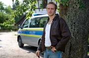 Marko Rackwitz (Felix Kruttke) wartet, während die Kriminaltechnik Erdproben nimmt.