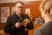 Der Schriftsteller Jan Weiler bekommt von Dr. Eckart (Christina Große) Getränke.