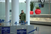 Der CBP-Aufsichtsbeamte Adams tr&auml;gt Zivilkleidung und einen Rucksack, als er bei seiner verdeckten Arbeit am Philadelphia International Airport in Philadelphia, Pennsylvania, die Gep&auml;ckausgabe durchstreift.