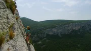 Ein Kletterer steigt eine steile Felswand hinauf, umgeben von zerklüfteten Klippen und dichtem grünen Wald im Hintergrund. Die Szene betont das Outdoor-Abenteuer in einer eindrucksvollen Naturkulisse. Ein Kletterer steigt eine steile Felswand hinauf, umgeben von zerklüfteten Klippen und dichtem grünen Wald im Hintergrund. Die Szene betont das Outdoor-Abenteuer in einer eindrucksvollen Naturkulisse.