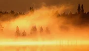 Sonne über dem Nebel taucht Finnlands Sümpfe in goldenes Licht