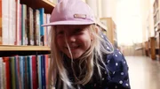 Vilda (Sofia Sittnikow) versteckt sich in der Bibliothek vor ihrem Vater.