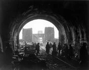 First U.S. Army men and equipment pour across the Remagen Bridge; two knocked out jeeps in foreground.