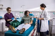 Dr. Leyla Sherbaz (Sanam Afrashteh, r.) und Assistenzarzt Oliver Probst (Arne Kert&eacute;sz, l.) versorgen die Schnittwunde des jungen Patienten Leon Harpin (Lukas von Horbatschewsky, M.), der zus&auml;tzlich zu seiner Verletzung stark dehydriert scheint. Dennoch will er sich nicht weiter behandeln lassen.