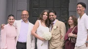 The Bride Kathrin and the groom Yassir are standing between Yassir's parents and siblings and smiling to the camera. Kathrin is holding a white flower bouquet.