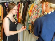 Eien Verk&auml;uferin zeigt Andrea (l.) passende Oberteile.