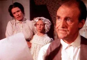 Mr. Oleson (Richard Bull, r.) hat nun endgültig genug, von den Ungezogenheiten seiner Adoptivtochter. Doch Mrs. Oleson (Katherine MacGregor, l.) mag nicht an die Schuld ihres Lieblings glauben und verteidigt Nancy (Allison Balson, M.).