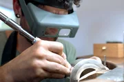 Damit die L&ouml;cher am Ausguss millimetergenau gebohrt werden, tr&auml;gt der Silberschmied eine Lupenbrille.
