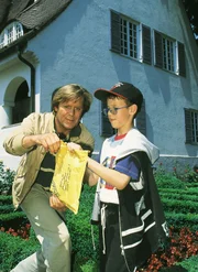Dr. Stefan Frank (Sigmar Solbach, re.) vermutet, da&szlig; der kleine Siggi (Sascha Dittmar) eine Briefbombe in der Hand hat...
