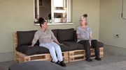 Beate (re.) und Freundin Ela bauen die Sitzgruppe aus Paletten auf.