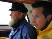 Willi Weitzel (rechts) verfolgt den Weg einer Postkarte von der norddeutschen Insel Langene&szlig; bis ins oberbayerische Murnau.