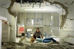 Als Hancock (Will Smith, hinten) Mary (Charlize Theron, liegend) k&uuml;sst, muss er erfahren, dass diese &uuml;ber &auml;hnliche Kr&auml;fte verf&uuml;gt. Sie schleudert ihn wutentbrannt durch die Haumauer ...