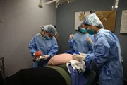 Dr. Lee holds up the shoulder lipoma she removed from Riki Roberts.