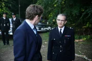 Inspektor Morse (Shaun Evans, l.) ruft in Eigeninitiative die gesamte Einheit herbei und muss diese Anordnung vor seinem Vorgesetzten, dem Chief Superintendent Reginald Bright (Anton Lesser, r.) gut begr&uuml;nden k&ouml;nnen. Wird der Chief Superintendant ihm glauben und seinem Verdacht nachgehen?
