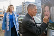 Sarah Marquardt (Alexa Maria Surholt, li.) erwischt ihren Kollegen Dr. Rolf Kaminski (Udo Schenk), wie er ein Wahlplakat der Bürgermeisterkandidatin Antonia Meiler (Muriel Baumeister, re.) verunglimpfen will.