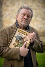 Will mit einer Neuauflage an frühere Erfolge seines Rätselbuchs anknüpfen: Autor Bertram Jewel (Jon Culshaw).