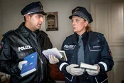 Unter Schenks selbstverlegten Krimis finden Tarik (Serhat Cokgezen, l.) und Claudia (Janette Rauch, r.) einen über die albanische Mafia. Sie fragen sich, ob daher die Verbindung zu dem angeblich albanischen Einbrecher kommt.