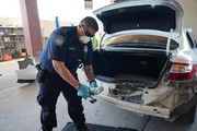 CBP-Beamter Salcido h&auml;lt ein Paket mit mutma&szlig;lichen Bet&auml;ubungsmitteln, das in der hinteren Sto&szlig;stange des Fahrzeugs eines Verd&auml;chtigen in El Paso, Texas, entdeckt wurde.