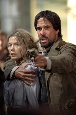 Butler (Kim Coates), einer von Baxters skrupellosen Revolverhelden, nimmt Sue (Annette Bening) als Geisel.