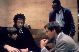 Was hat der Achtj&auml;hrige gesehen? V. li. n. re.: Samuel Lapp (Lukas Haas) mit seiner Mutter Rachel (Kelly McGillis) und den Ermittlern John Book (Harrison Ford) und James McFee (Danny Glover).