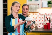 Vera (Sybille Waury, links) und Sarah (Sophie Reiml, rechts) beguatchten ihren Kuchen f&uuml;r den Backwettbewerb der Landfrauen.