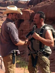 L-R: Jeff Zausch legt EJ Snyder ein Gurtzeug an.