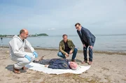 Die Leiche von Frank Loose (Arne Fuhrmann, liegend.) gibt den Kommissaren Finn Kiesewetter (Sven Martinek, 2.v.r.) und Lars Englen (Ingo Naujoks, r.) und Rechtsmediziner Dr. Henning Strahl (Christoph Tomanek, l.) einige Fragen auf.