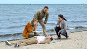 In den frühen Morgenstunden wird der dominikanische Hotelier Miguel Hernandez (Alberto Ruano, liegend) tot am Strand aufgefunden. Dr. Helene Sturbeck (Katharina Blaschke, l.) vermutet, dass er erschossen wurde. In seiner Kleidung finden Lars Pöhlmann (Dominic Boeer, M.) und Karoline Joost (Nike Fuhrmann, r.) neben seinem Reisepass auch den Brief eines Wismarer Notariats. Warum hat sich Miguel auf den weiten Weg nach Deutschland gemacht? In den frühen Morgenstunden wird der dominikanische Hotelier Miguel Hernandez (Alberto Ruano, liegend) tot am Strand aufgefunden. Dr. Helene Sturbeck (Katharina Blaschke, l.) vermutet, dass er erschossen wurde. In seiner Kleidung finden Lars Pöhlmann (Dominic Boeer, M.) und Karoline Joost (Nike Fuhrmann, r.) neben seinem Reisepass auch den Brief eines Wismarer Notariats. Warum hat sich Miguel auf den weiten Weg nach Deutschland gemacht?