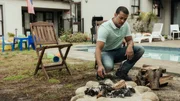 Nathan Residence - Garden: Eric (BLAZE AGULHAS) throws another log on the fire and gives Nathan (CHASE AGULHAS) a beer.