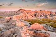 Das Licht der frühen Morgensonne bringt die zerklüfteten Felsformationen der Badlands zum Leuchten.