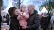 Yuliana Brahina und Denys Bragyn mit ihrer kleinen Tochter Eva auf einem Weihnachtsmarkt in Hamburg.