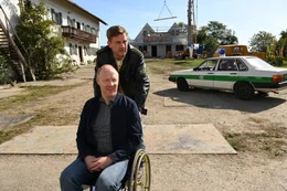 Rudi (Simon Schwarz, vorne) sitzt, obwohl er offiziell als geheilt gilt, weiterhin im Rollstuhl und gibt Franz (Sebastian Bezzel) die Schuld am Unfall und m&ouml;chte nun auf dem Eberhofer-Hof rundum versorgt werden.
