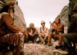 Sam Hawkens (Ralf Wolter, l.), Lord Castlepool (Eddi Arent, M.) und Old Shatterhand (Lex Barker, r.) rauchen die Friedenspfeife mit dem Stamm der Utahs.