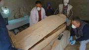 Der große Moment! Zum Schutz vor Krankheitserregern tragen die Ägyptologen beim Öffnen des alten Holzsarkophags Atemschutzmasken.