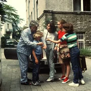 Im Schlafanzug will Werner (Peter Weck, l.) seine Familie Tom (Tarek Helmy, 2. v. l.), Angi (Thekla Carola Wied, M.), Tanja (Julia Biedermann, 2. v. r.) und Markus (Timmo Niesner, r.) in die Schule oder das Gesch&auml;ft fahren. Angis alter VW ist nicht angesprungen.