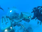 Darrell and crew next to submarine under water. Darrell and crew next to submarine under water.