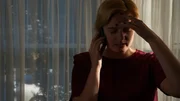 Recre of Kristine talking on phone with one hand on her forehead.