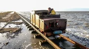 Postschiffer Johann Petersen transportiert die Weihnachtspakete. Bei Flut schwappt die Nordsee über den Lorendamm.