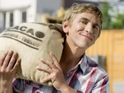 Fritz Fuchs (Guido Hammesfahr) mit einem Sack echter Kakaobohnen. Nur wie macht man daraus Schokolade?