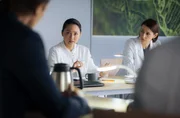 Dr. Lilly Phan (Mai Duong Kieu, li.) setzt sich über die Anweisung der neuen Chefärztin hinweg und stellt ihr experimentelles Verfahren im ärztlichen Konsil vor. re.: Dr. Maria Weber (Annett Renneberg)