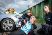 Auf der Suche nach dem vermissten Onkel der Braut finden Tarik (Serhat Cokgezen, l.) und Kim (Carolyn Genzkow, r.) Theo Metzner (Eric Bouwer, M.) verletzt vor der Hochzeitslimousine.