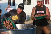 Freddy Dodge and Rick Ness pouring potatoes in water at goldweigh barbecue.