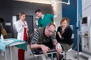 Alex Rode (Jan Hartmann, r.) und Dr. Caro Diehl (Jytte-Merle Böhrnsen, l.) sehen sich mit Margot Röver (Heike Thiem-Schneider) den Po ihres Mannes Wolfgang Röver (Hartmut Volle) an, der mit 22 blutigen Schrotkugeln versehen ist. Alex Rode (Jan Hartmann, r.) und Dr. Caro Diehl (Jytte-Merle Böhrnsen, l.) sehen sich mit Margot Röver (Heike Thiem-Schneider) den Po ihres Mannes Wolfgang Röver (Hartmut Volle) an, der mit 22 blutigen Schrotkugeln versehen ist.