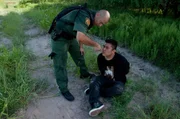 Laredo, TX: An agent giving a handcuffed man water. Dehydration is a dangerous possibility when crossing the border. Laredo, TX: An agent giving a handcuffed man water. Dehydration is a dangerous possibility when crossing the border.