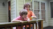 Hemphill family sons blow bubbles on the back porch in family package segment in episode 209, as seen on HGTV's House Hunters Family