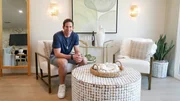 Tarek El Moussa sitting posed in the house post flip, as seen on The Flipping El Moussas, Season 2.